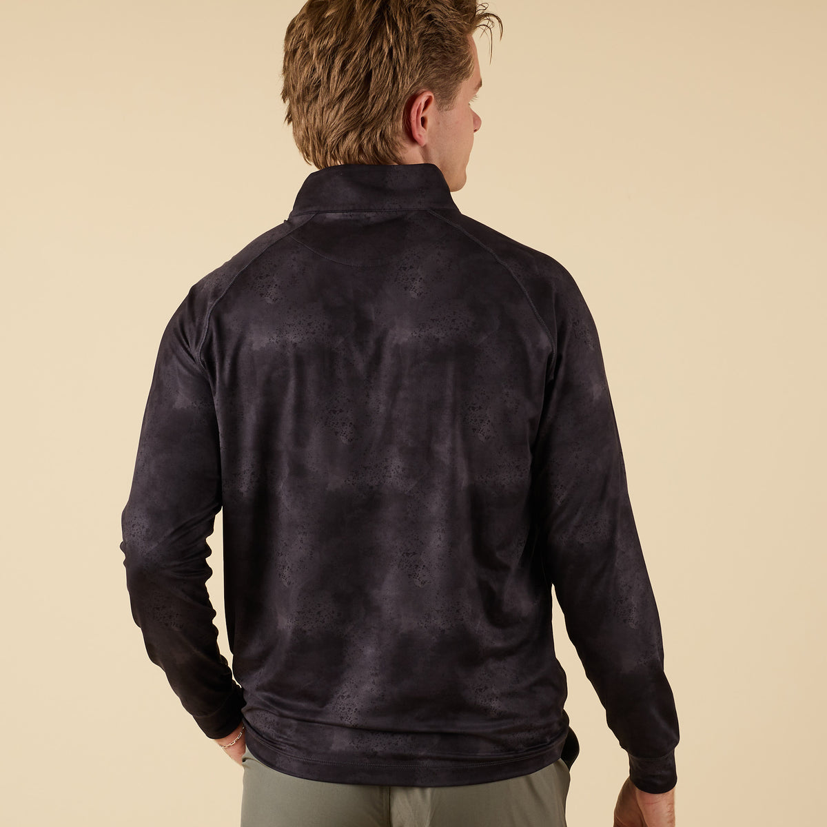 Back view of men’s black camo performance quarter-zip showing tonal camo print.