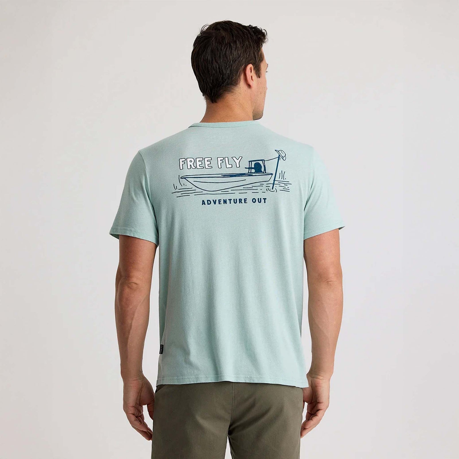 Back view of light mint Free Fly t-shirt with navy line art of a boat and "Adventure Out" slogan.
