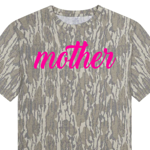 Camo t-shirt with “mother” graphic in pink lettering shown in close-up view.