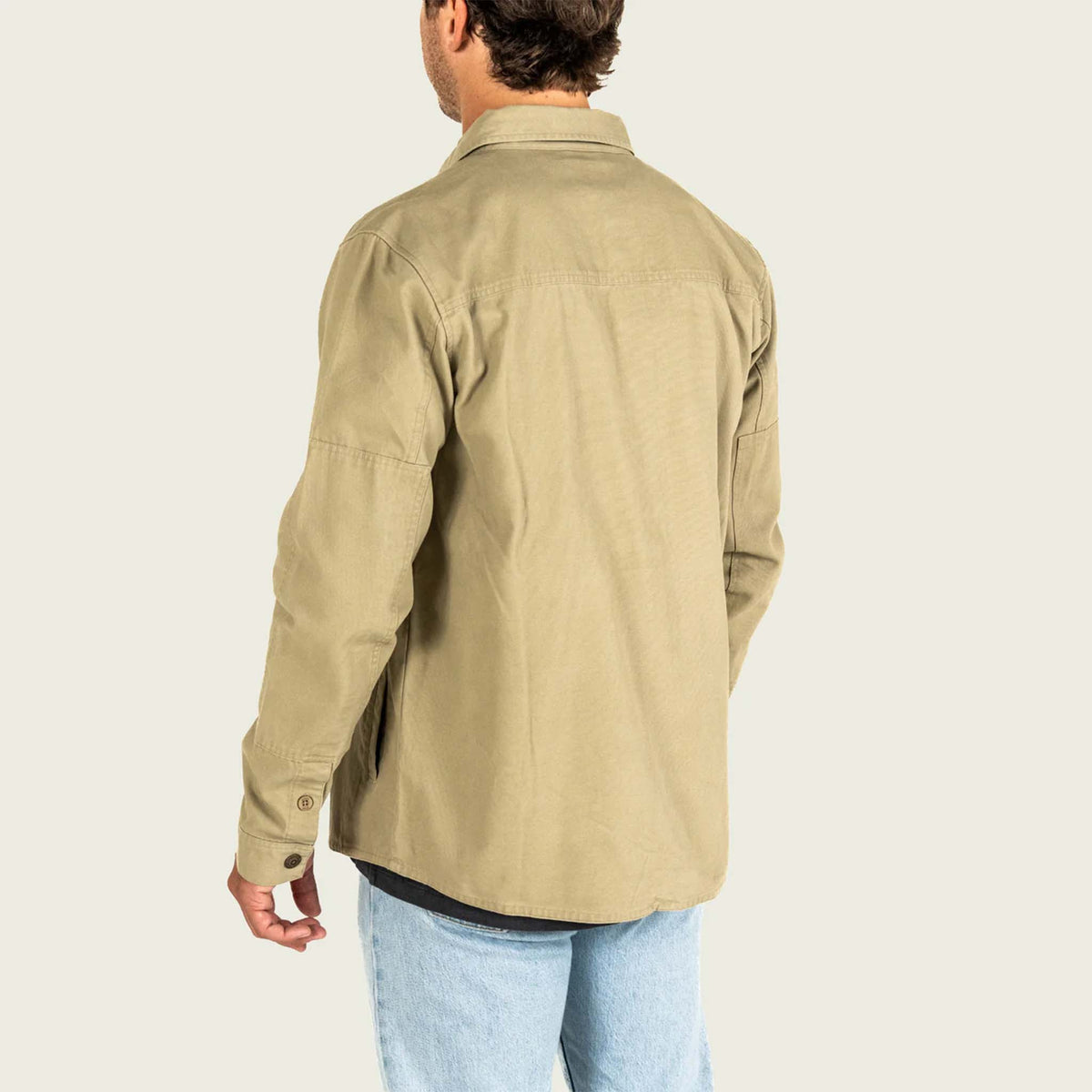 Person wearing a beige jacket on a light gray background