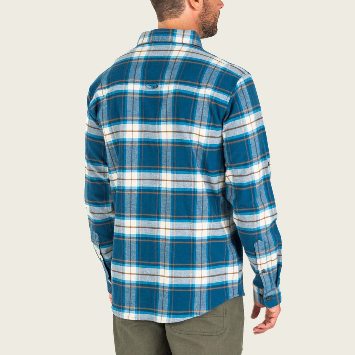 Man wearing a blue plaid shirt on a plain background