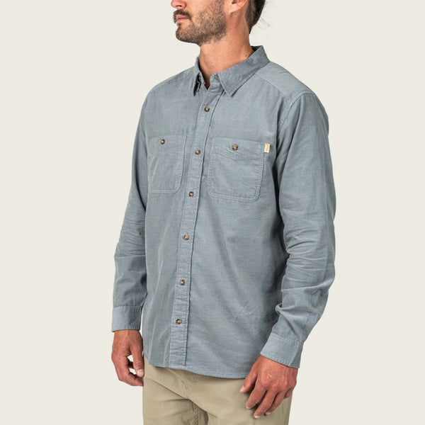 Man wearing a steel grey button-up shirt on a beige background