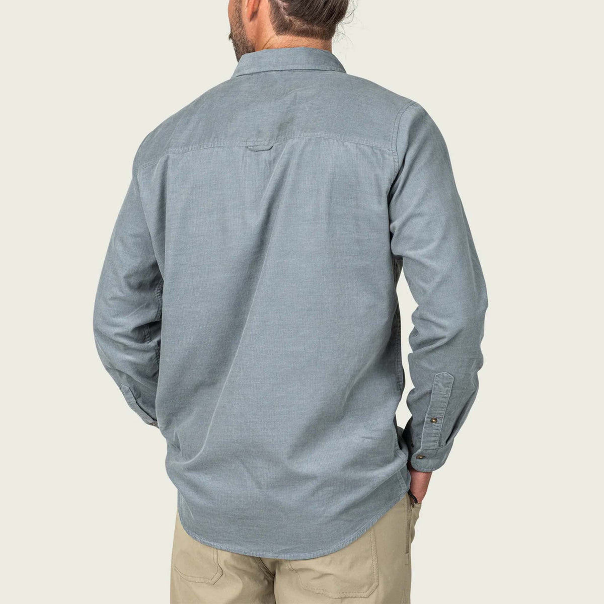 Man wearing a steel grey button-up shirt on a plain background