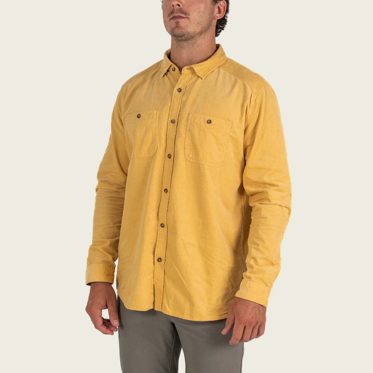 Man wearing a yellow corduory shirt on a white background