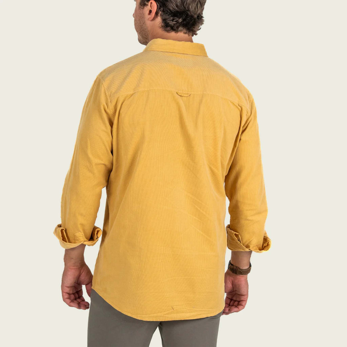 Man wearing a mustard yellow shirt on a white background