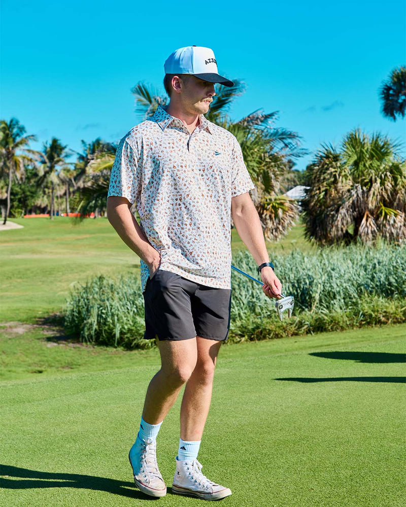 Man walking on a golf course with a club in his hand.
