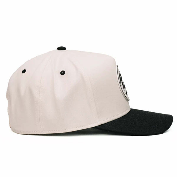 Two-toned 5-panel high crown trucker hat with an off-white front and black pre-curved bill. Features an off-white and black rubber 'Nuthin’ Fancy' patch on the front, black mesh back panels, and an adjustable plastic snapback closure. One size fits most.
