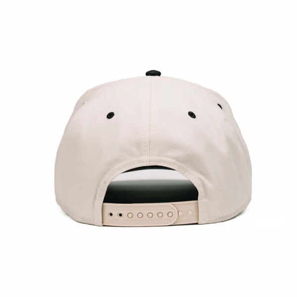 Two-toned 5-panel high crown trucker hat with an off-white front and black pre-curved bill. Features an off-white and black rubber 'Nuthin’ Fancy' patch on the front, black mesh back panels, and an adjustable plastic snapback closure. One size fits most.