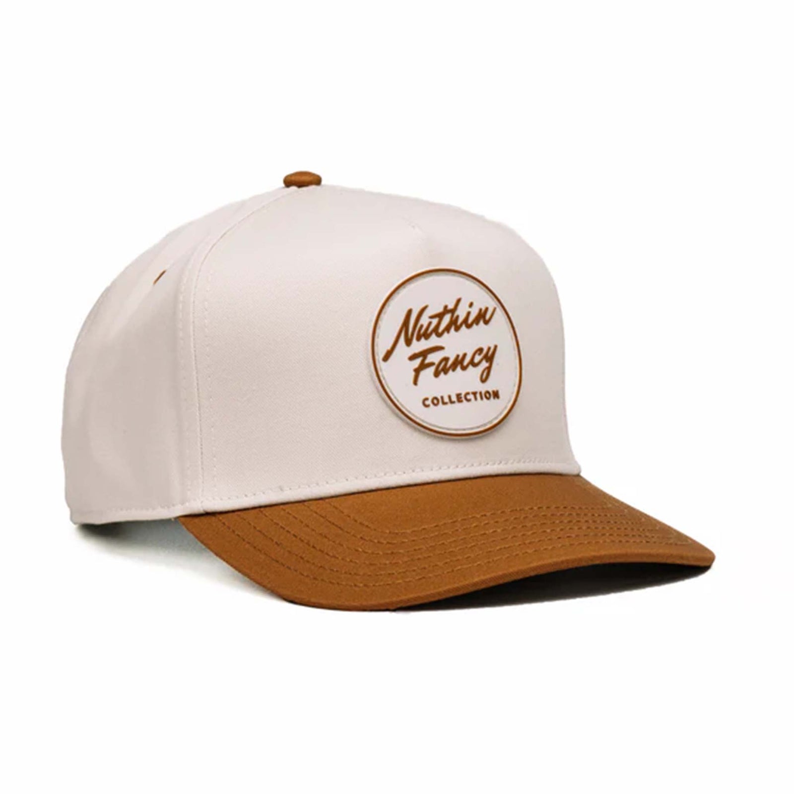 Two-toned 5-panel high crown trucker hat with an off-white front and rust-colored pre-curved bill. Features an off-white and rust rubber 'Nuthin’ Fancy' patch on the front, rust mesh back panels, and an adjustable plastic snapback closure. One size fits most.