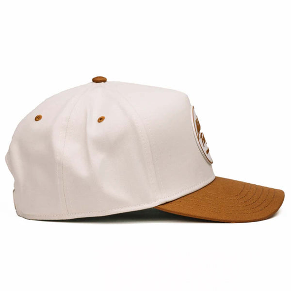 Two-toned 5-panel high crown trucker hat with an off-white front and rust-colored pre-curved bill. Features an off-white and rust rubber 'Nuthin’ Fancy' patch on the front, rust mesh back panels, and an adjustable plastic snapback closure. One size fits most.