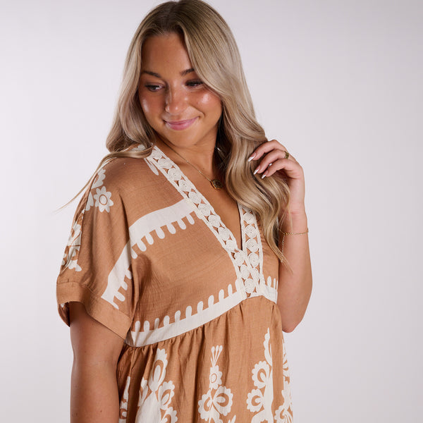  Woman wearing a brown dress with white patterns on a white background