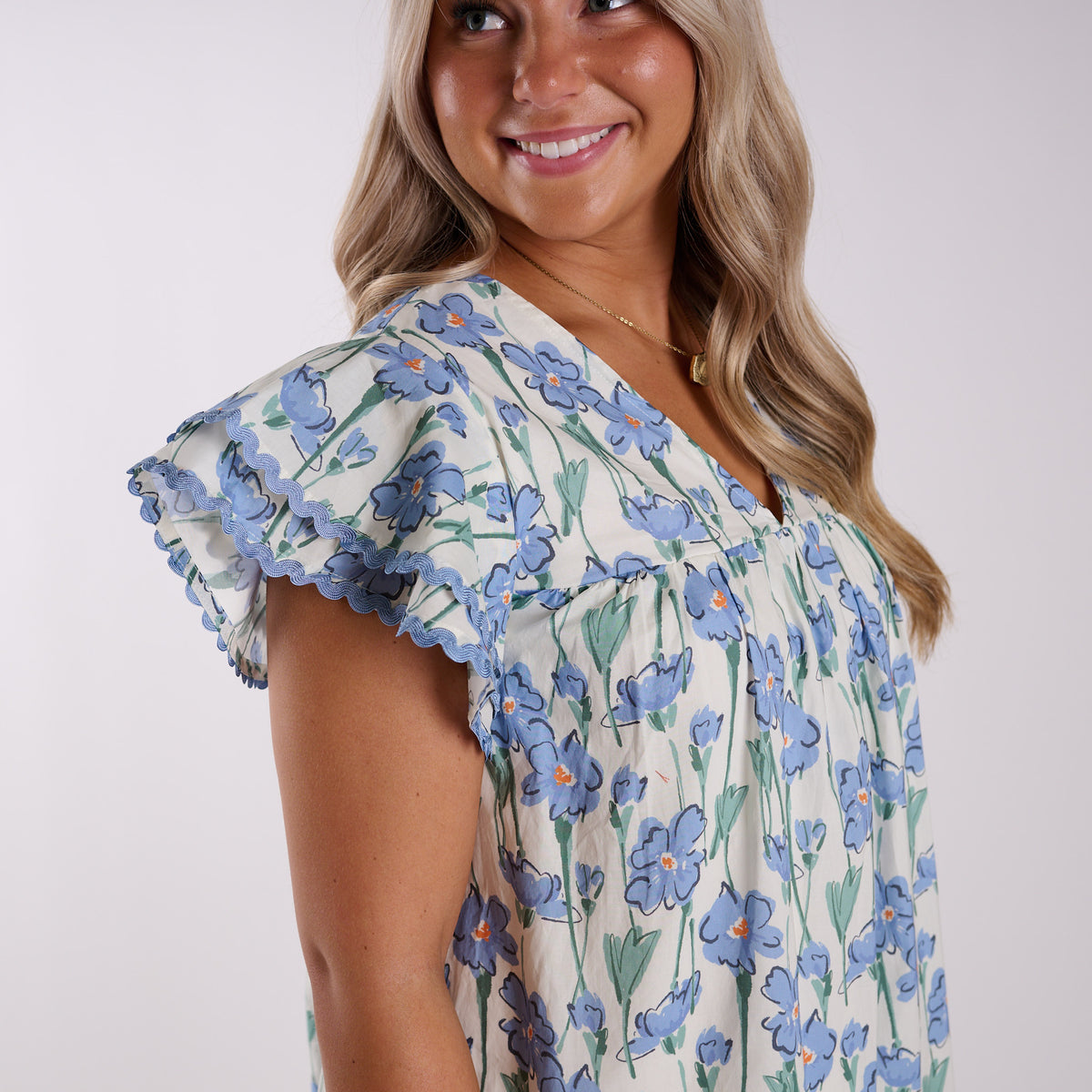 Up close view of flutter sleeve on blue floral dress.