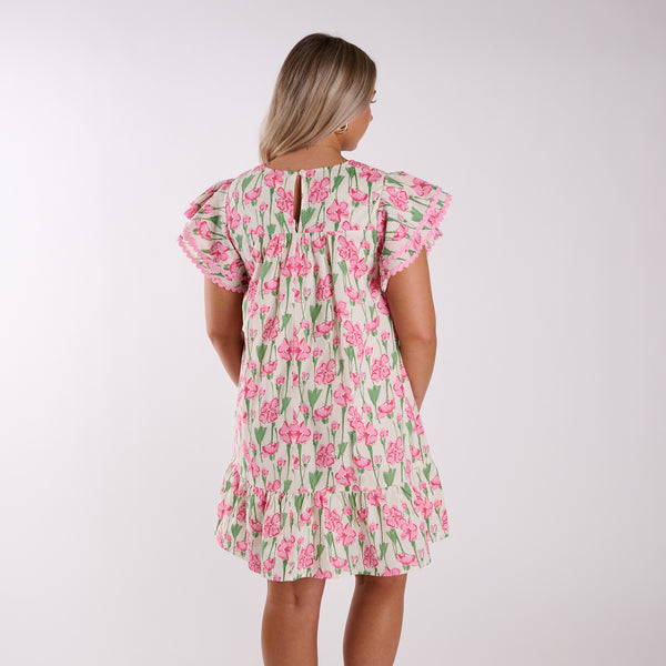  Back view of woman wearing a pink floral dress.