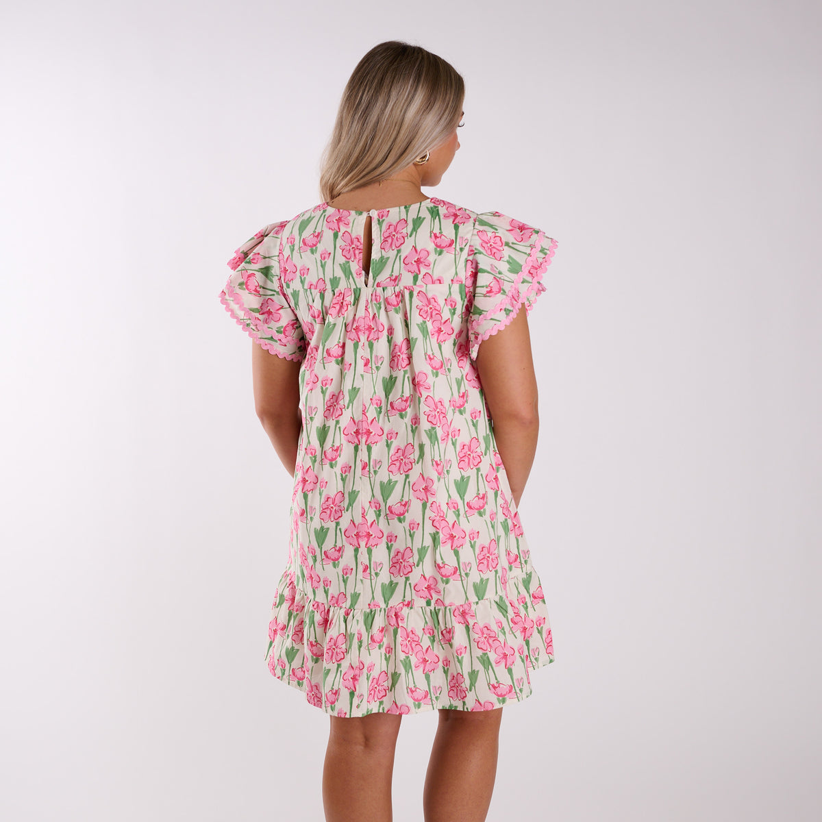 Back view of woman wearing a pink floral dress.