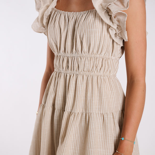  Beige ruffled dress with a plain background