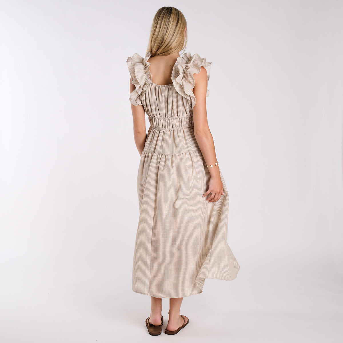 Taupe | Woman wearing a beige dress with ruffled sleeves on a white background