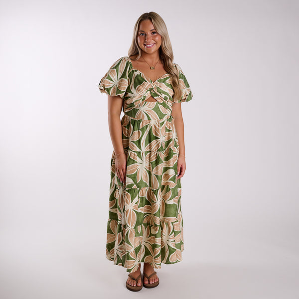 Woman wearing a green and beige patterned dress on a white background