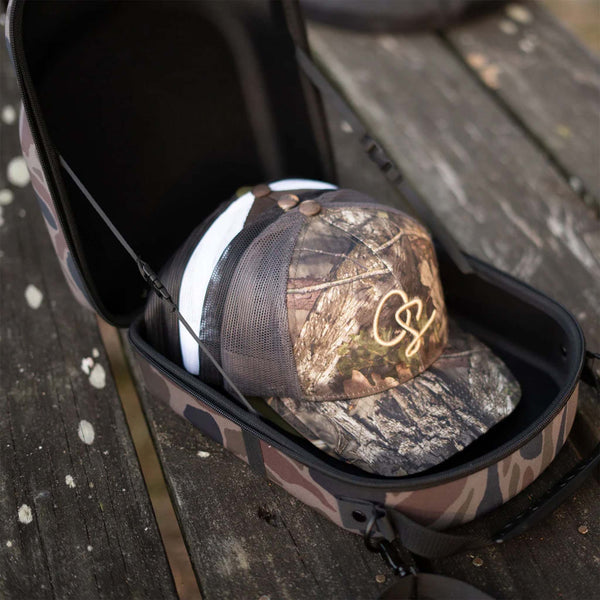 Open view of Old South 6 Hat Travel Case in color Thicket Camo.  The case is open showing 6 hats stacked neatly inside for convenient and secure travel.
Our Old South - 6 Hat Travel Case is perfect for when you're on the go or in need of storage for your caps. The all-over light weight foam protects your caps from damage and the elements. An out of the way luggage and shoulder strap will fit ensure your hats are not far away!