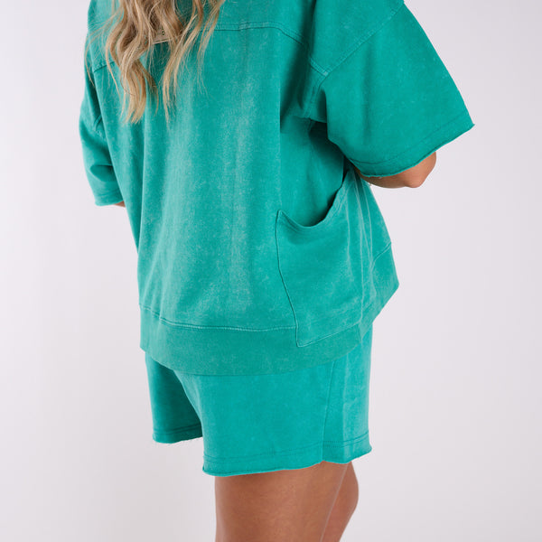 Green oversized shirt and shorts set on a white background