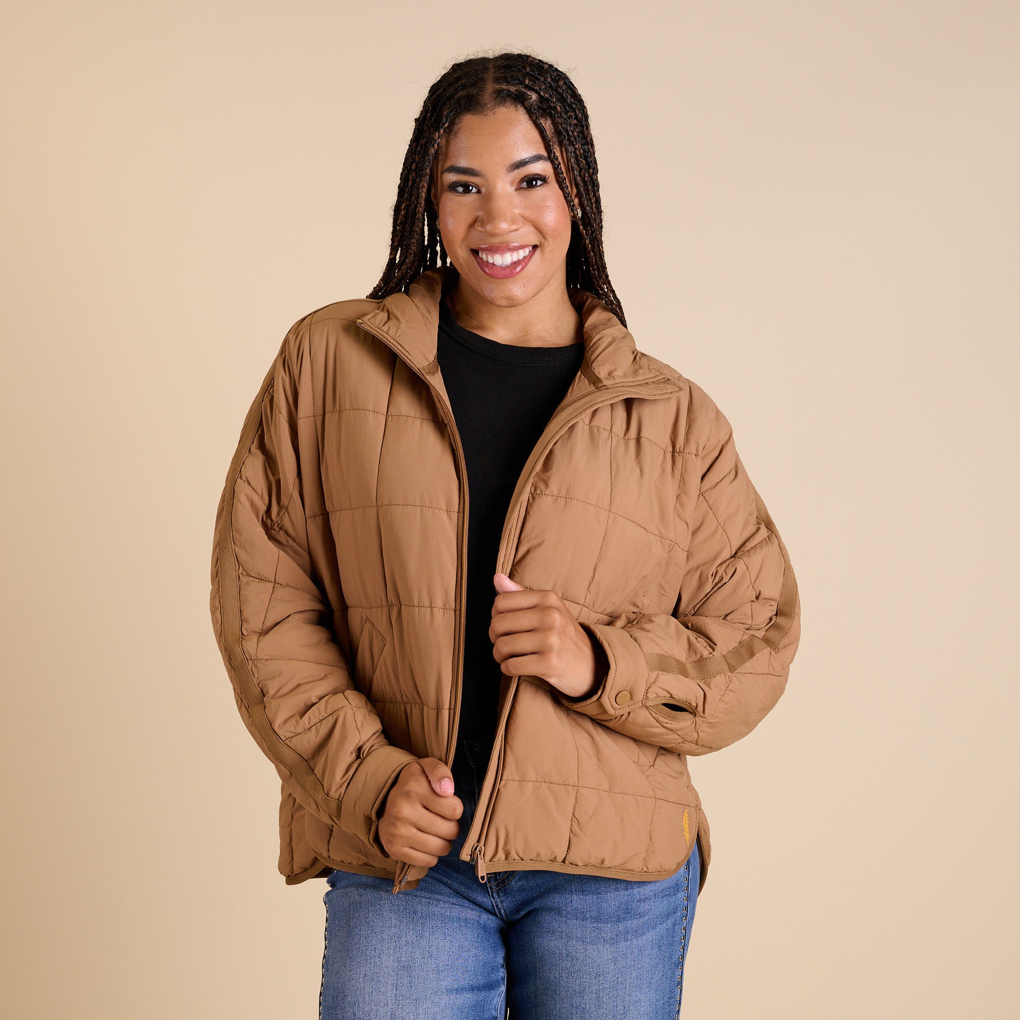 Woman wearing a brown quilted jacket on a beige background