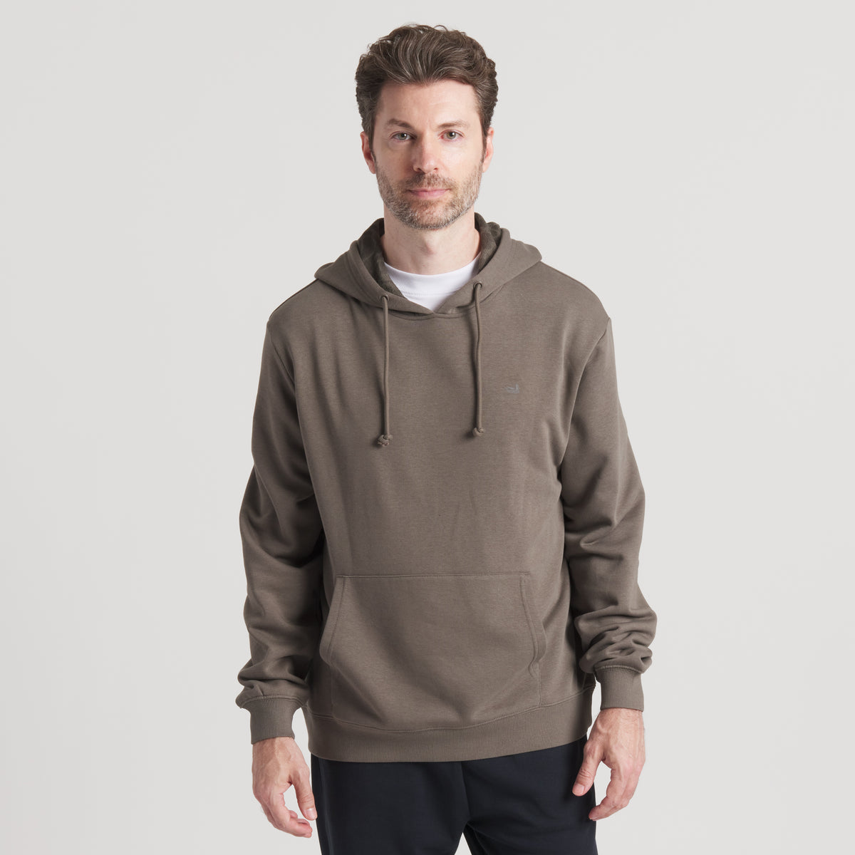 Front view of model wearing dark brown hoodie with kangaroo pocket and drawstrings.