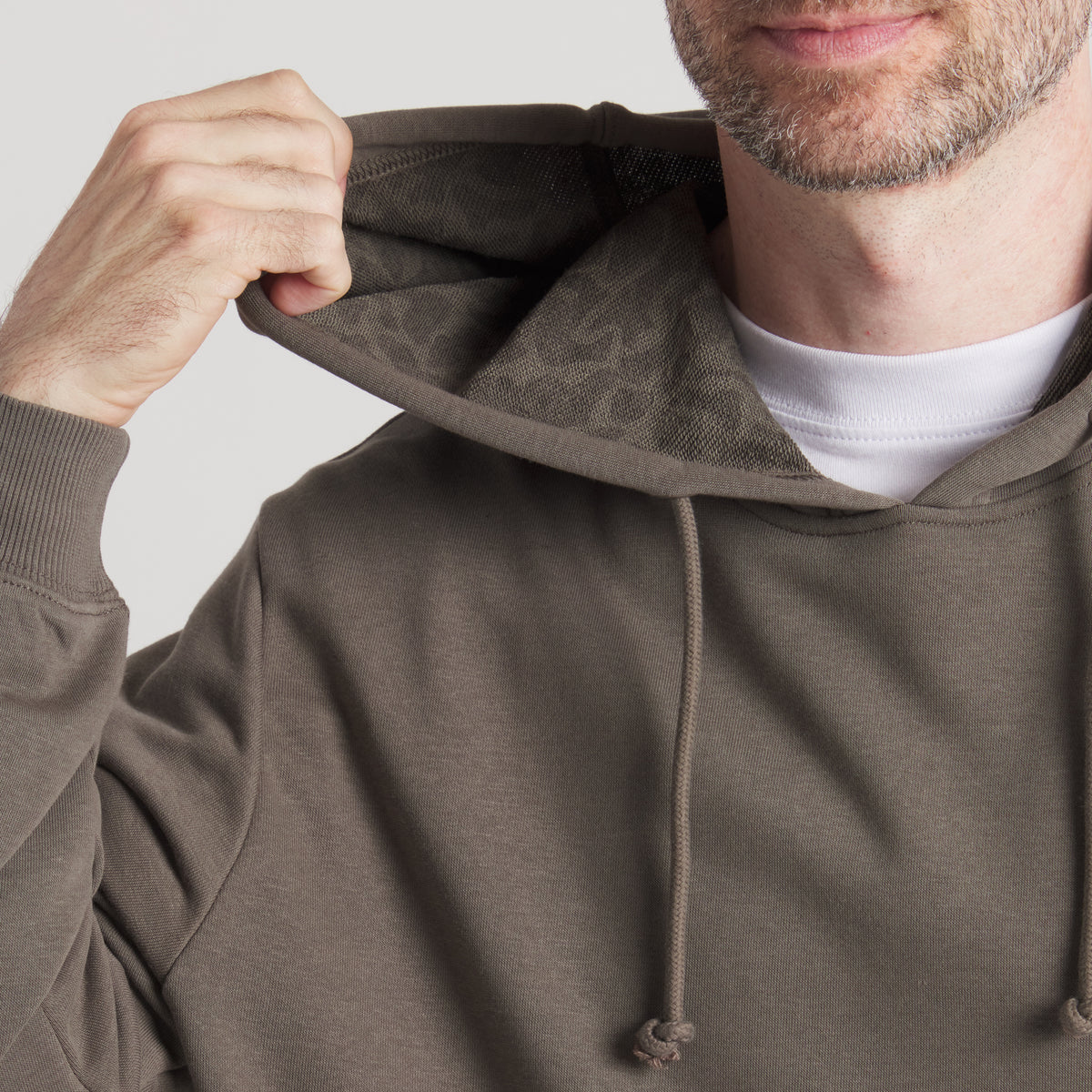 Close-up of dark brown hoodie with hood lifted, showing tonal animal print lining.