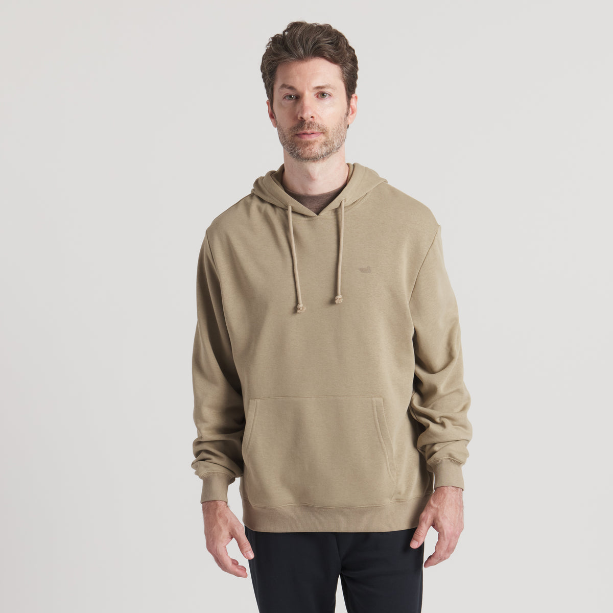 Man wearing a beige hoodie on a light gray background