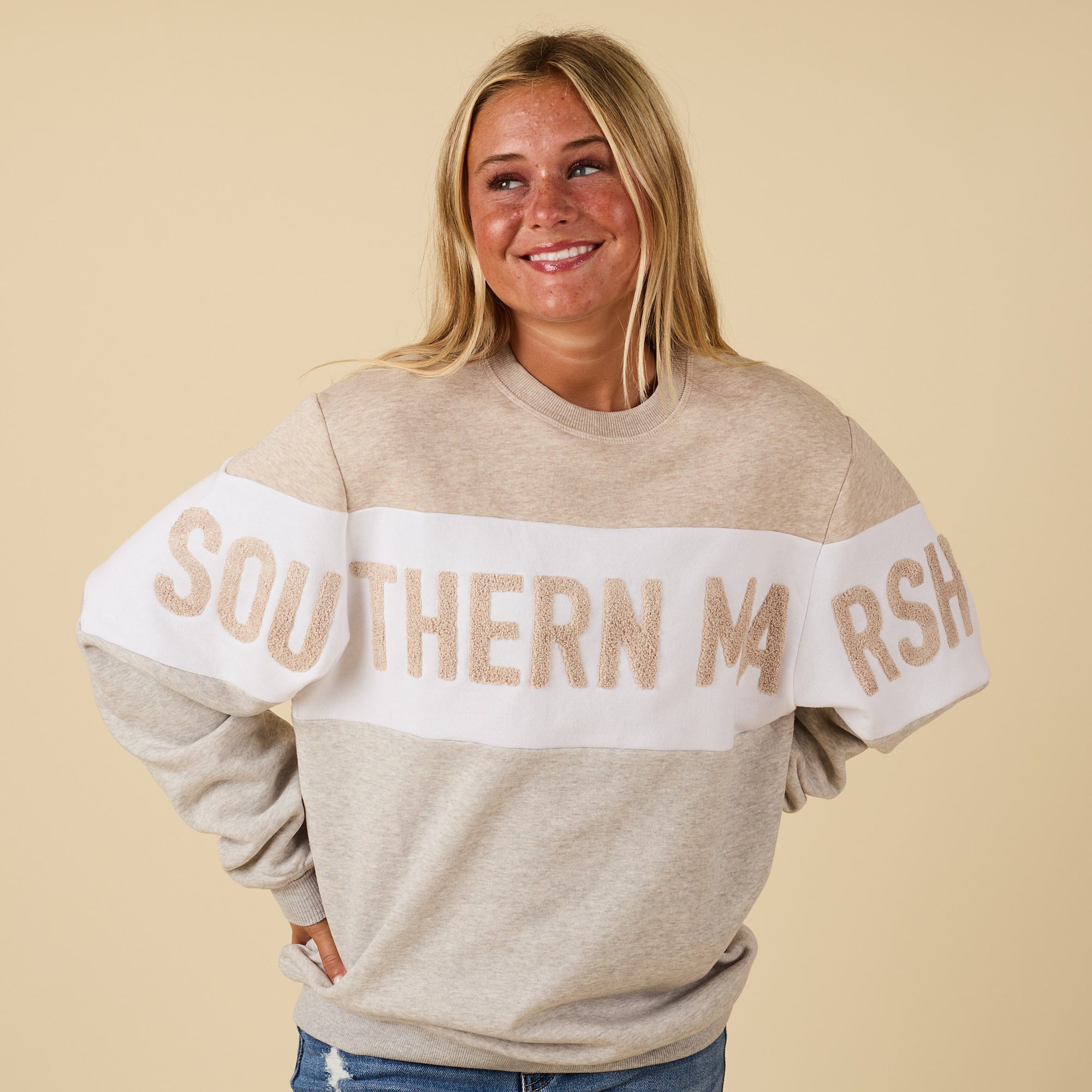 Woman wearing a beige sweatshirt with 'SOUTHERN NASH' text on a beige background
