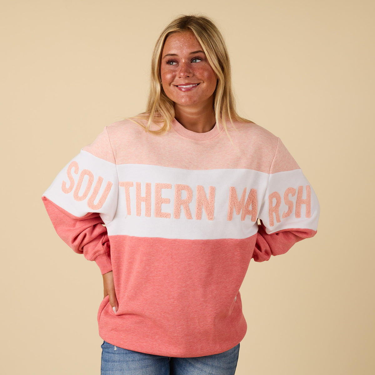 Front view of peach pink Southern Marsh oversized sweatshirt with chenille applique lettering across chest and arms.