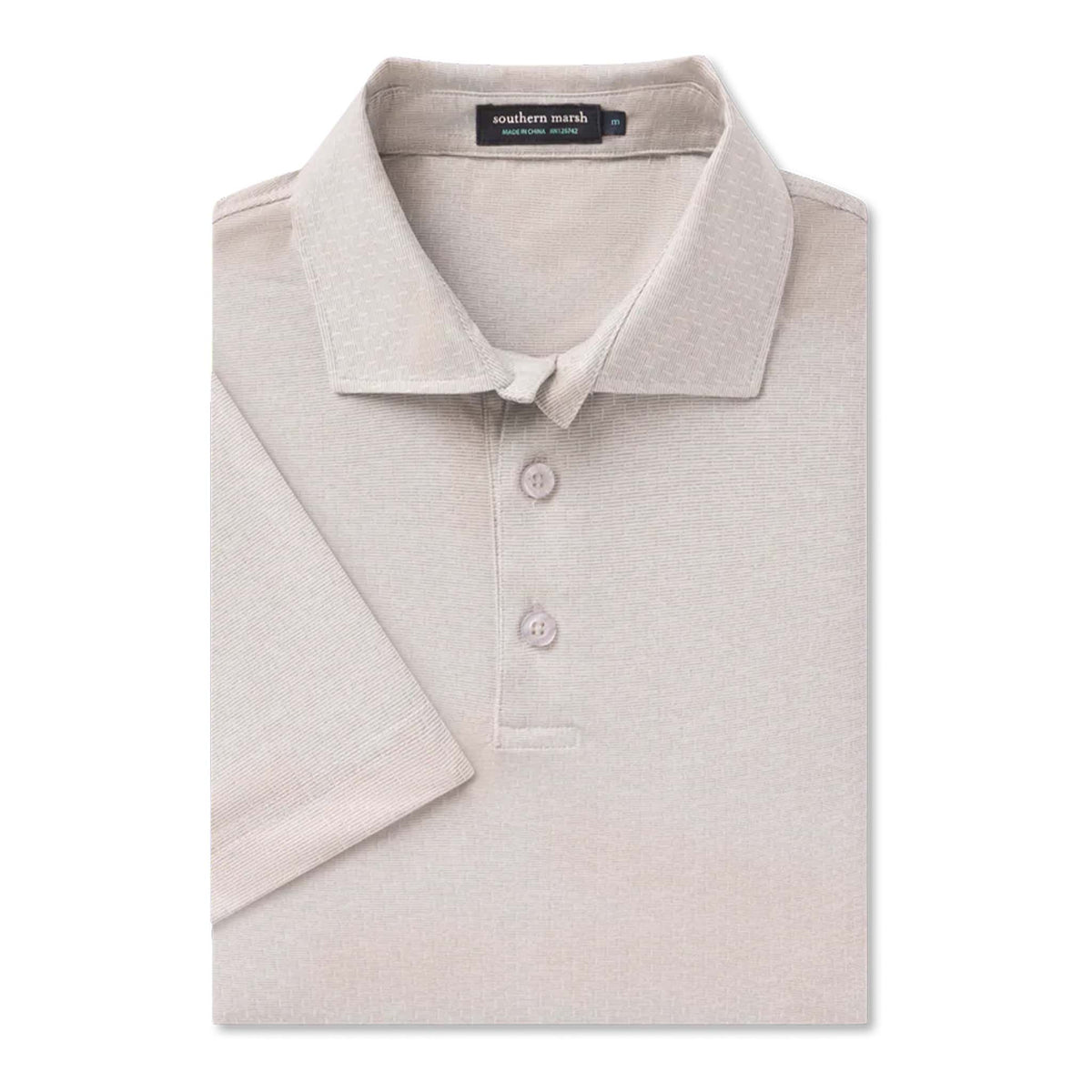 Folded beige polo shirt with 'southern marsh' label on a white background