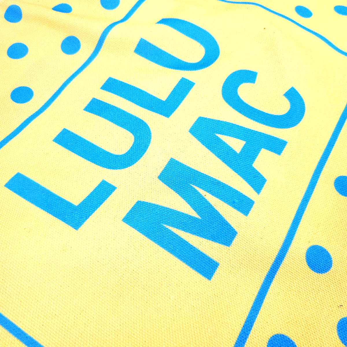 Yellow/Blue | Bright yellow canvas tote bag with turquoise blue polka dot pattern and 'LULU MAC' branding on a white background