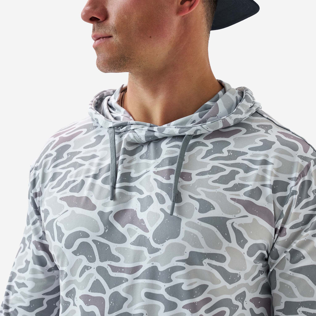 Person wearing a gray camouflage-patterned hoodie on a white background