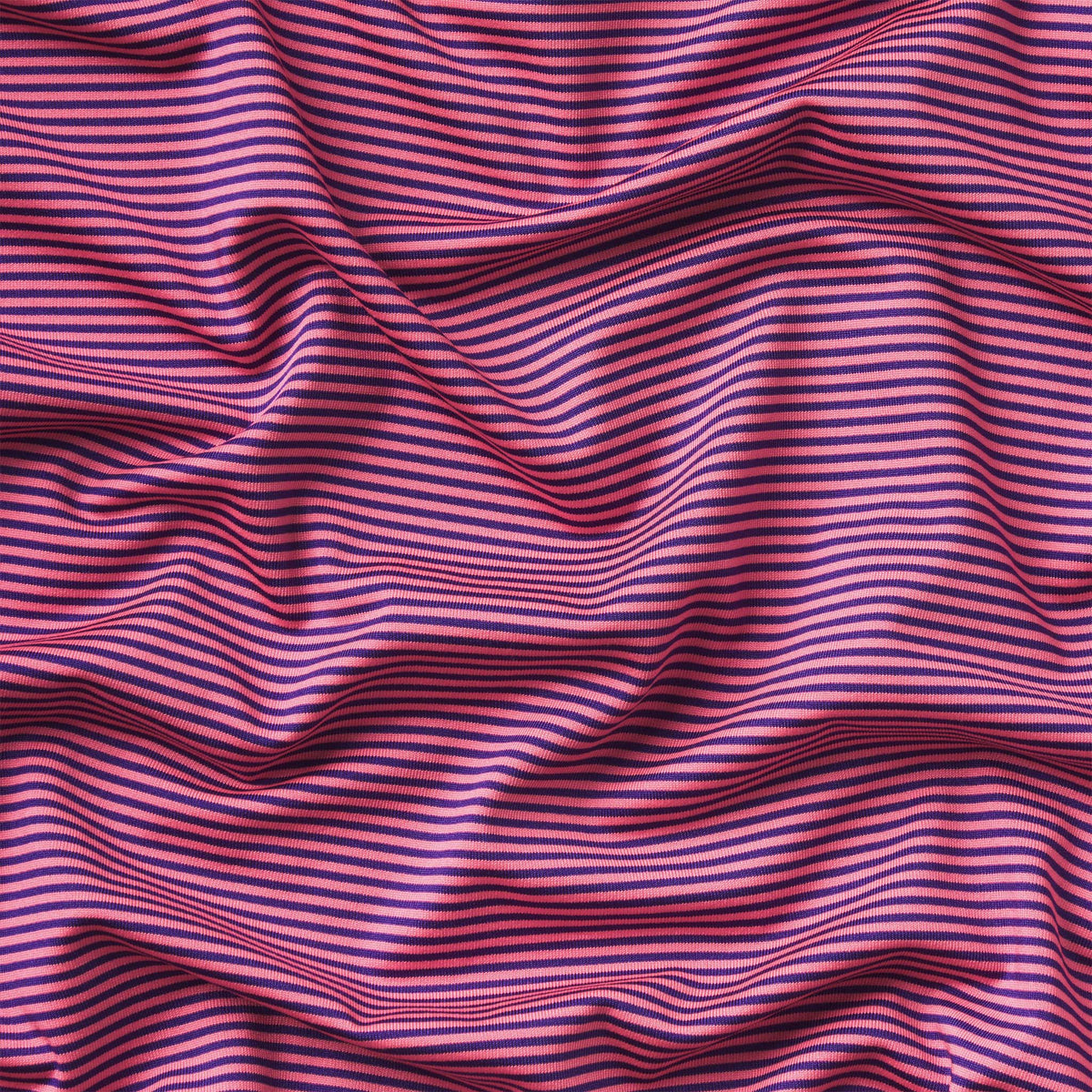 Close up of navy and strawberry pink striped fabric.
