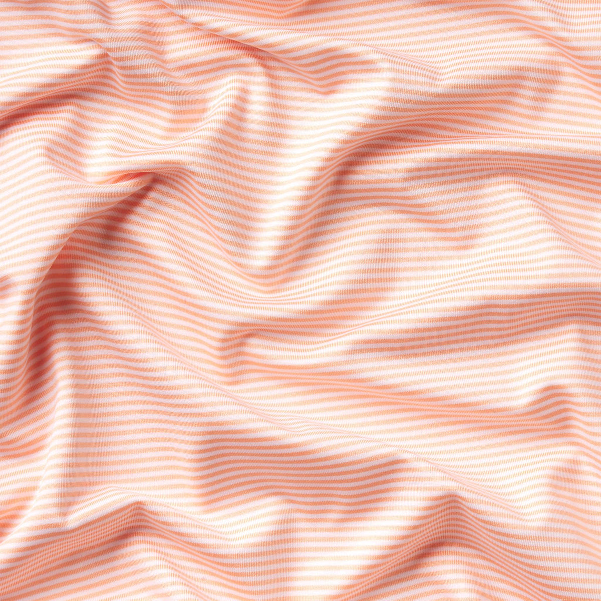 Close-up of light peach and white horizontal striped fabric.