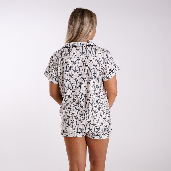 Person wearing a patterned shirt and shorts set on a white background