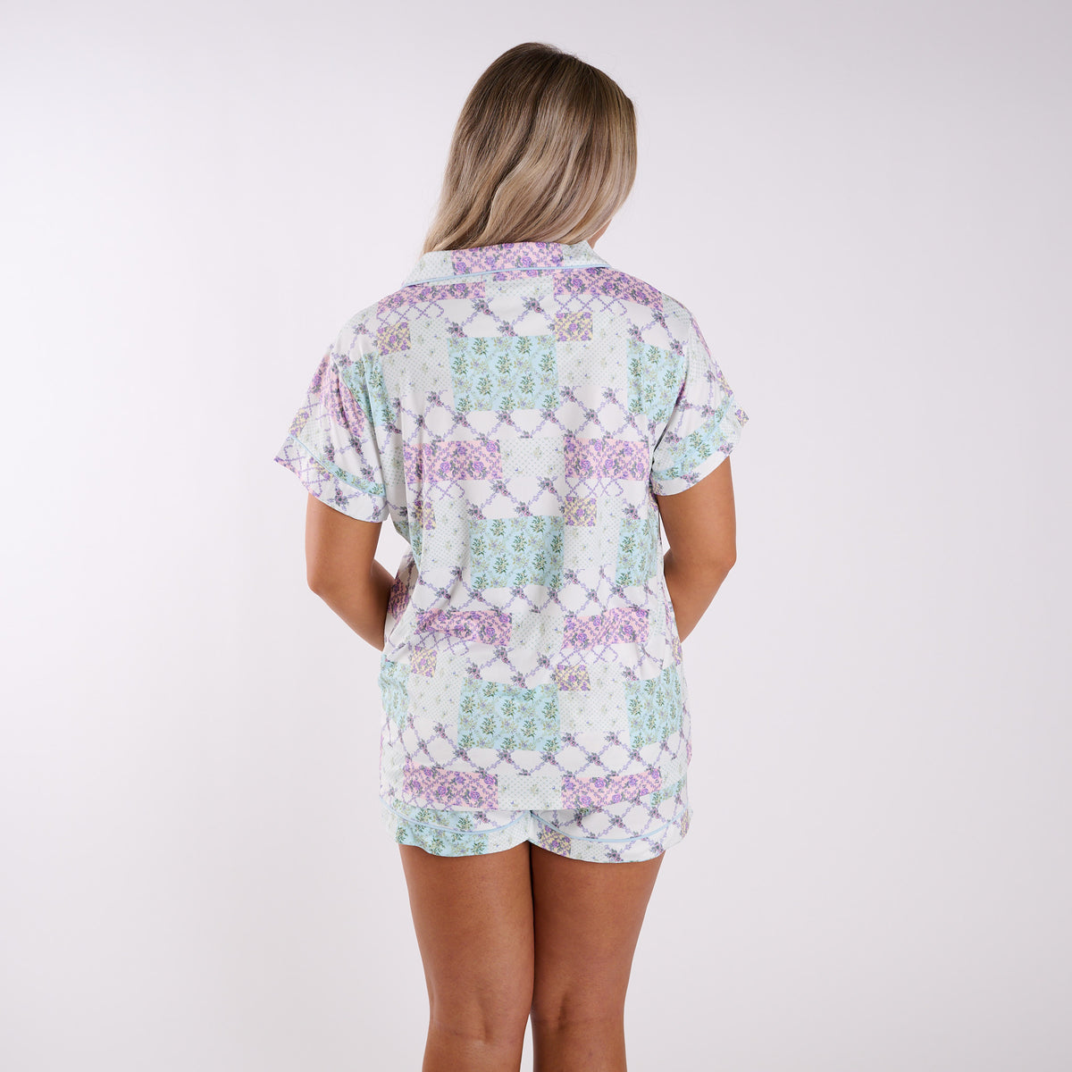 Woman wearing a patterned pajama set on a white background