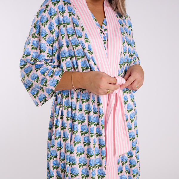 Pink floral robe detail showing side pocket and lace trim hem with blue hydrangea print.