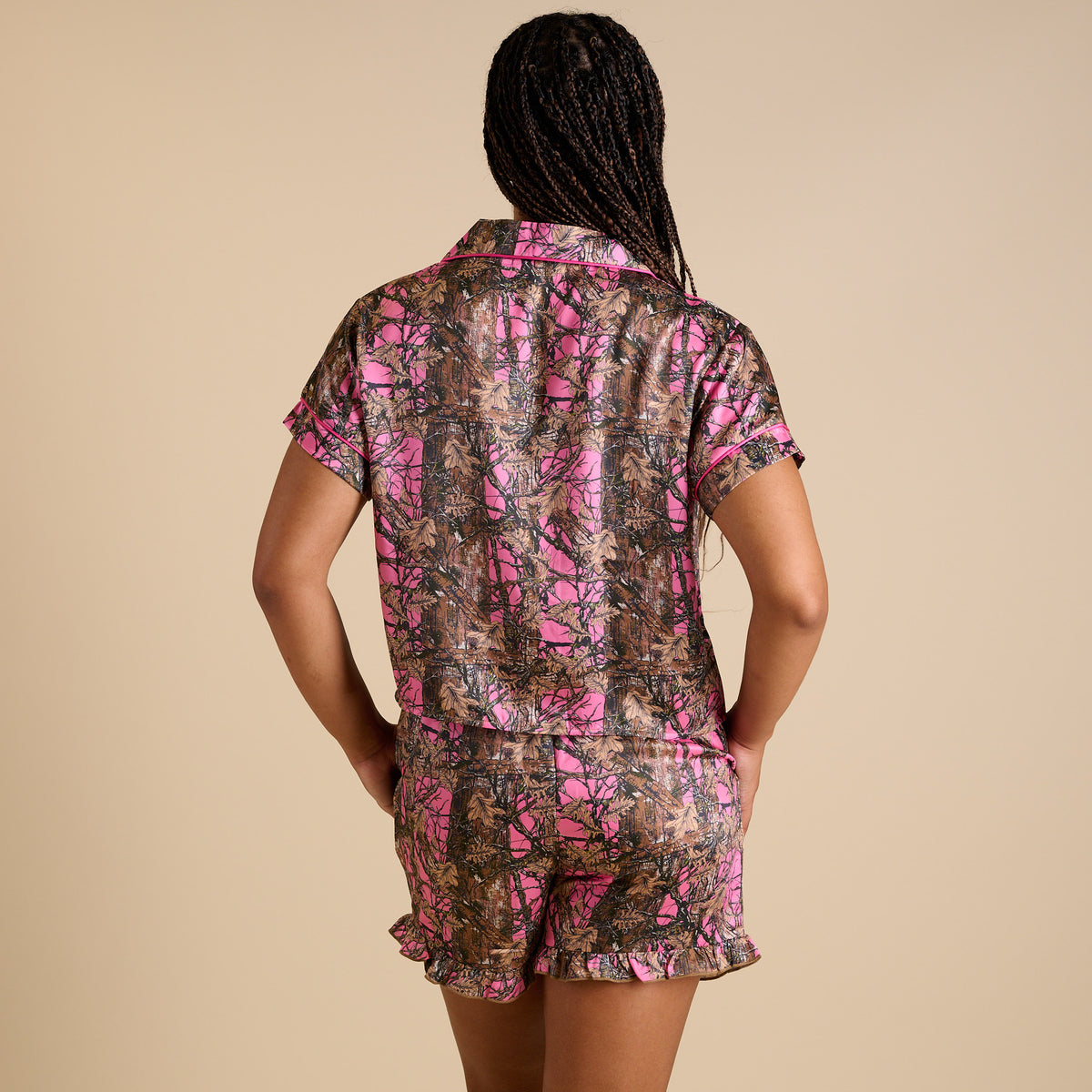 Back view of women’s Simply Southern pink camo pajama set with button-down top and ruffle shorts.