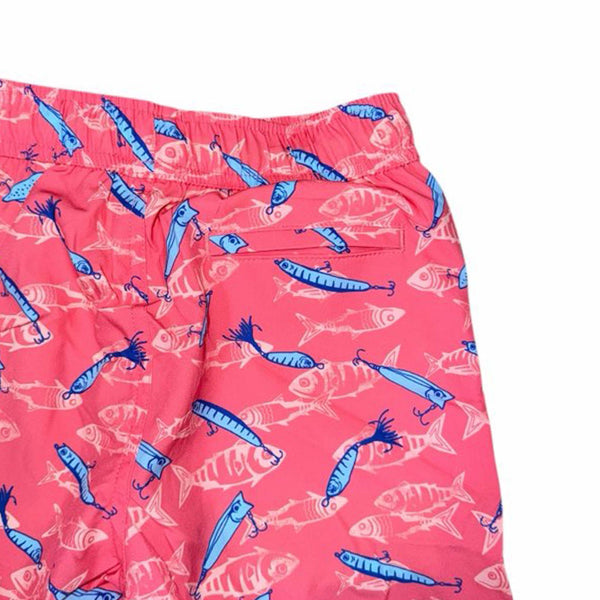 Close up of back pocket of youth coral swim trunks with fish and hook pattern.