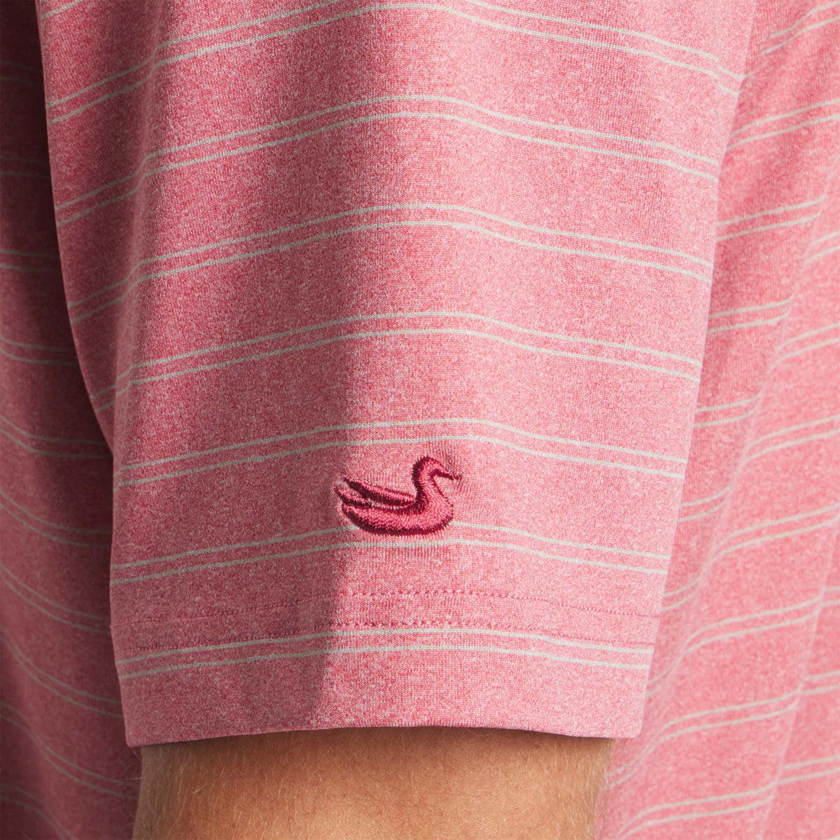 Close-up of a red and white striped shirt with a small logo on the chest.