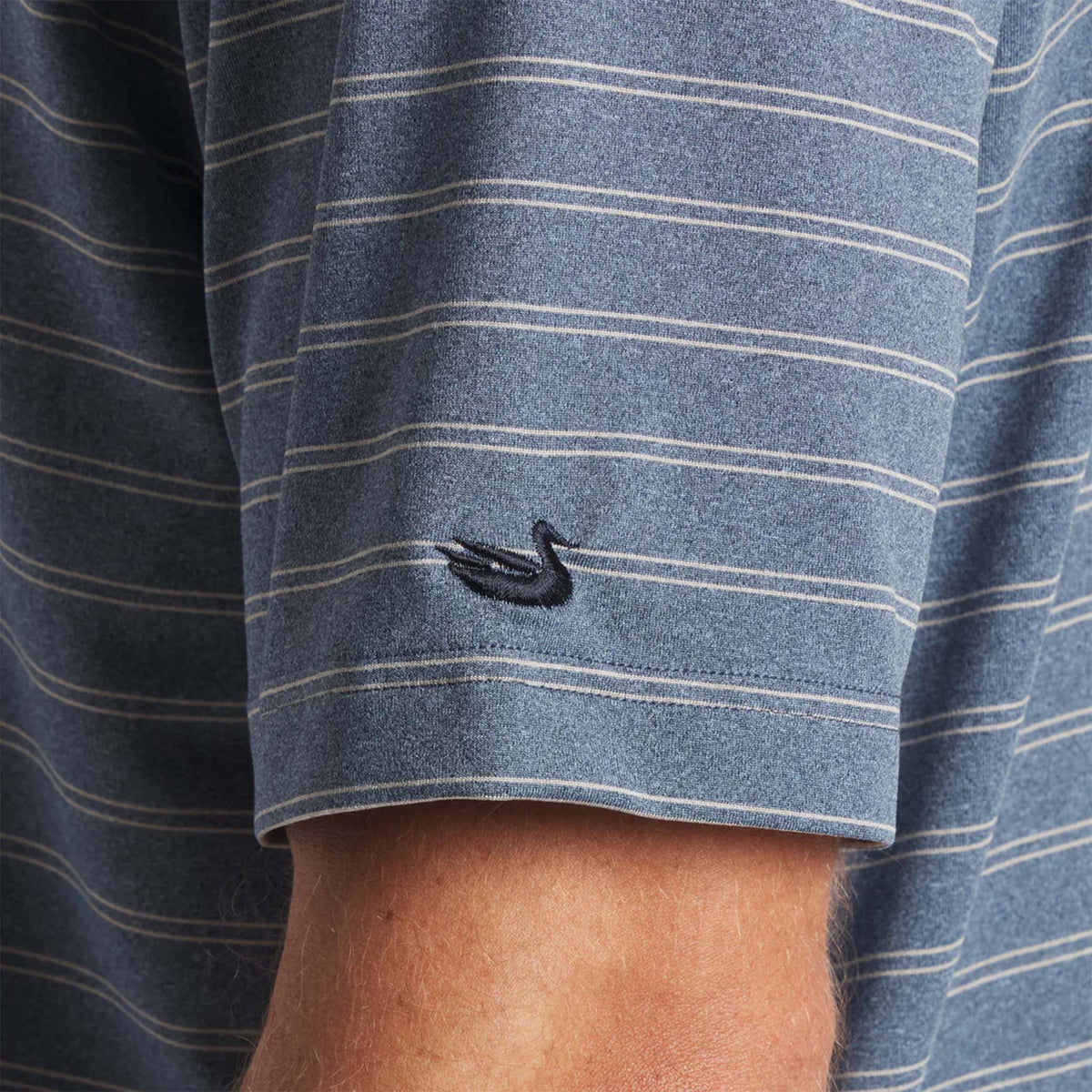 Close-up of a blue and gray striped shirt with a small logo on the sleeve.