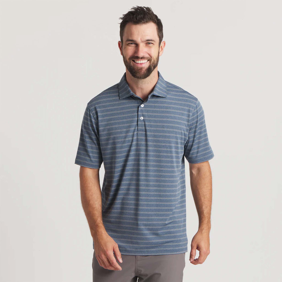 Man wearing a blue striped polo shirt on a light gray background