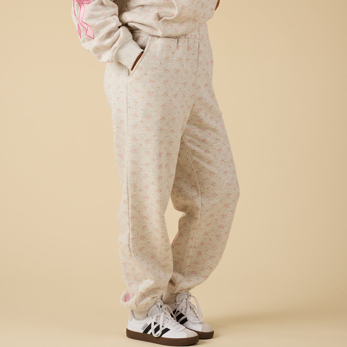 side view of Alice Pink Bow Sweatpants in floral print with relaxed fit and pockets.