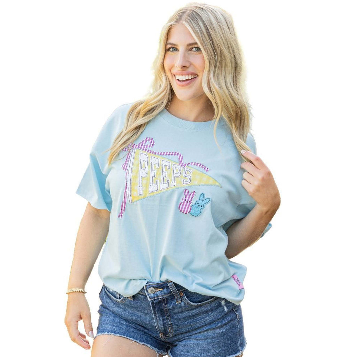 Woman wearing Simply Southern blue Peeps pennant graphic t-shirt styled with denim shorts.
