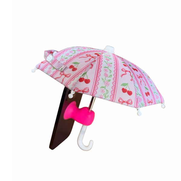 Pink mini umbrella with cherry design attached to a smart phone shown on a white background