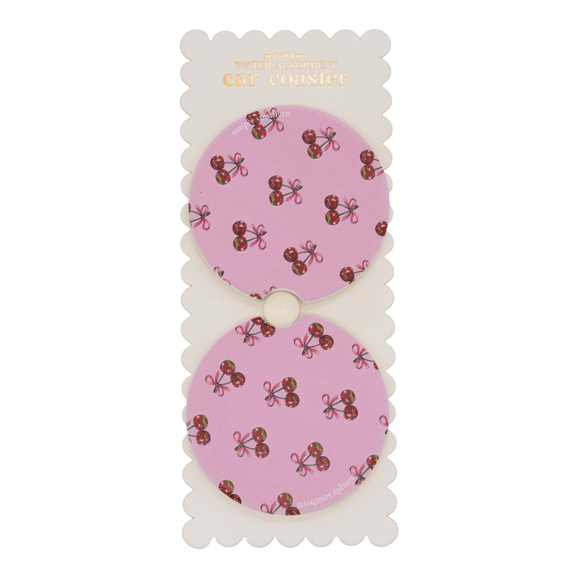 Set of two round car coasters with cut-out notch, displayed on backing card, featuring a pink background with repeating cherry and bow pattern.