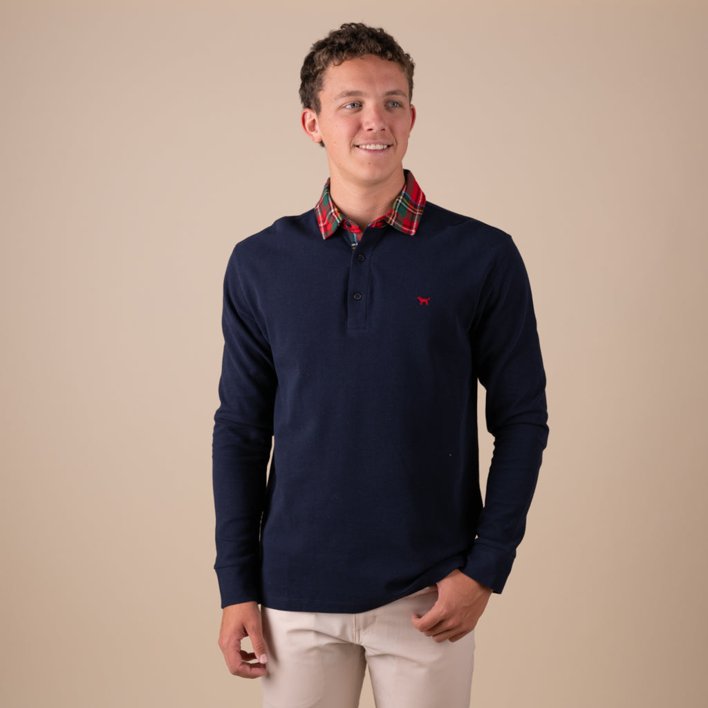 Man wearing a navy long sleeve polo with a red plaid collar.