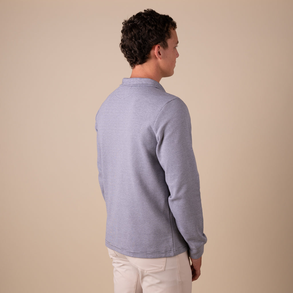 Man wearing a light blue sweater against a beige background