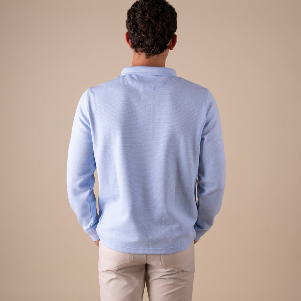 Man wearing a light blue sweater against a beige background