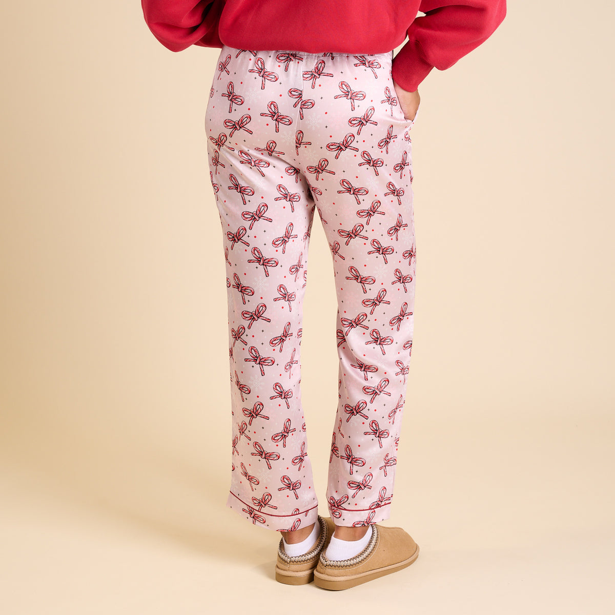 Back view of candy cane bow pajama pants with elastic waistband and side pockets.
